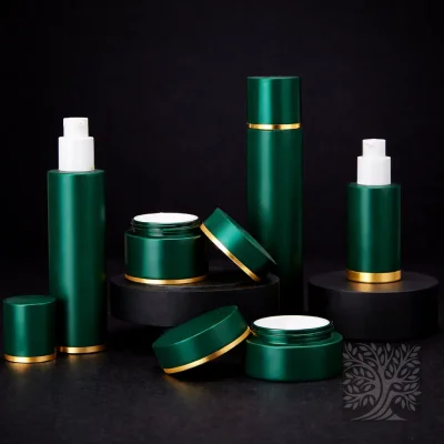 Emerald green skincare bottles and cosmetic jars with gold trim, arranged on black platforms with lids set aside.