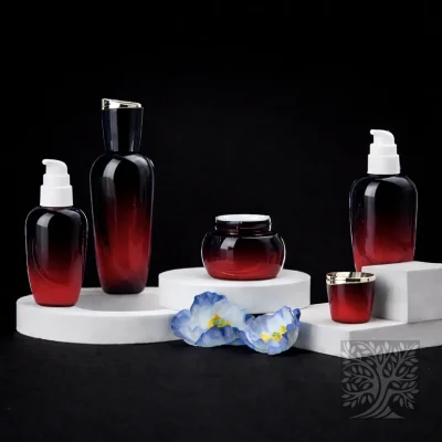 Black to red gradient glass bottles and cosmetic jars with gold accents, arranged in a bold, high-contrast composition.