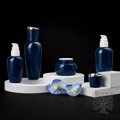 Deep navy blue glass bottles and cosmetic jars with gold caps, arranged with flowers in a clean Aurelius product display.