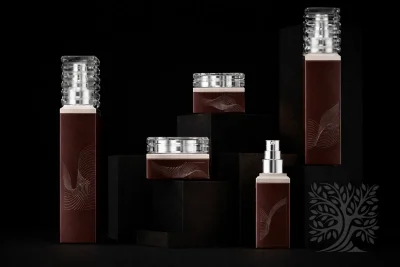 Rich brown glass bottles and matching cosmetic jars with silver caps, arranged in a balanced product grouping.