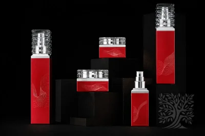 Bright red square serum bottles and cosmetic jars with silver caps, arranged in a cohesive Monument packaging display.