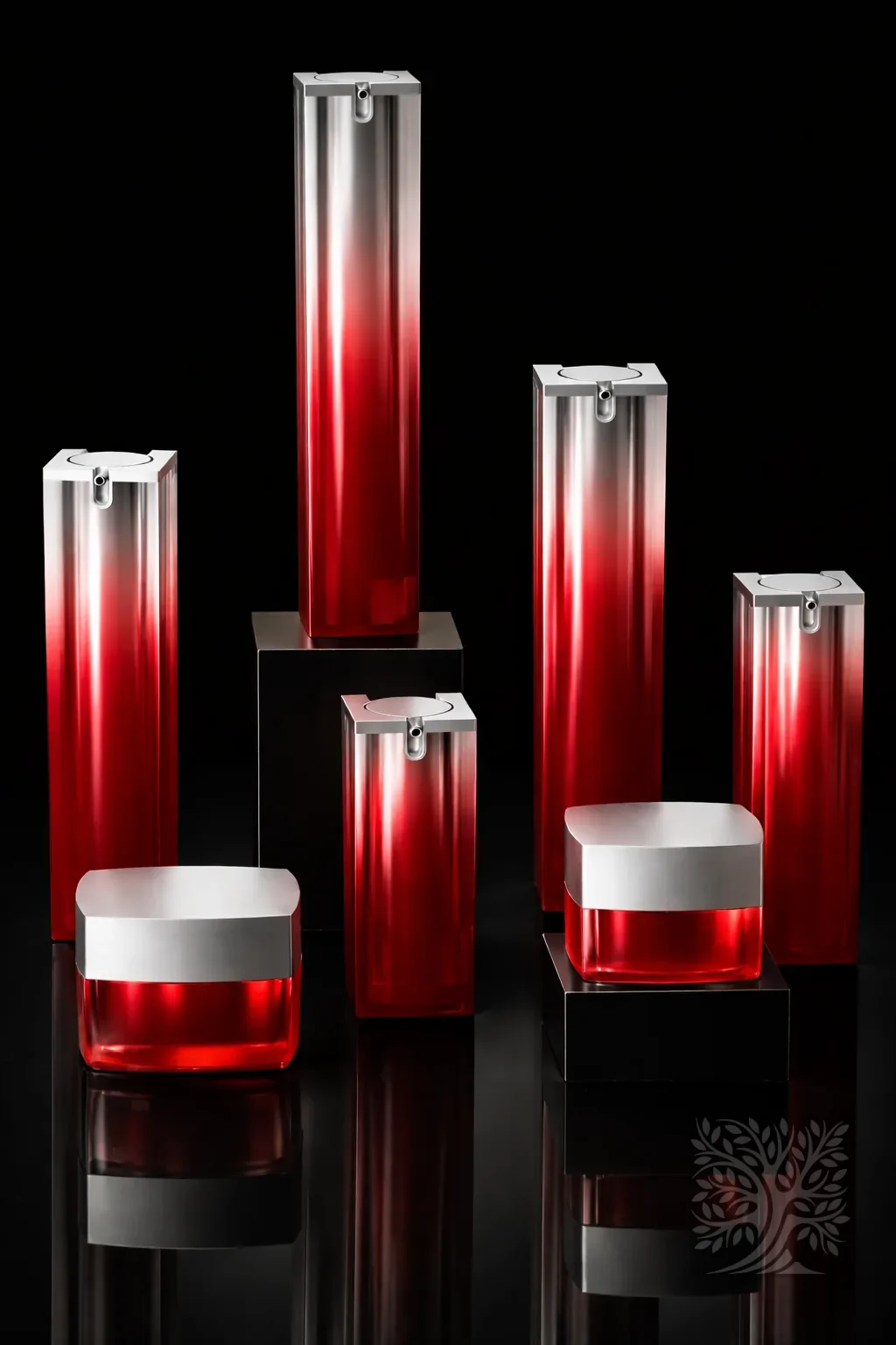 Red gradient acrylic serum bottles and jars with silver lids, transitioning from clear to deep red in a cohesive set.