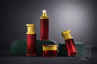 Deep red acrylic skincare bottles and cosmetic jars with gold caps, arranged on stands with upright and angled bottle display.